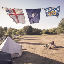 Weißzelt im Lager mit drei wehenden Flaggen